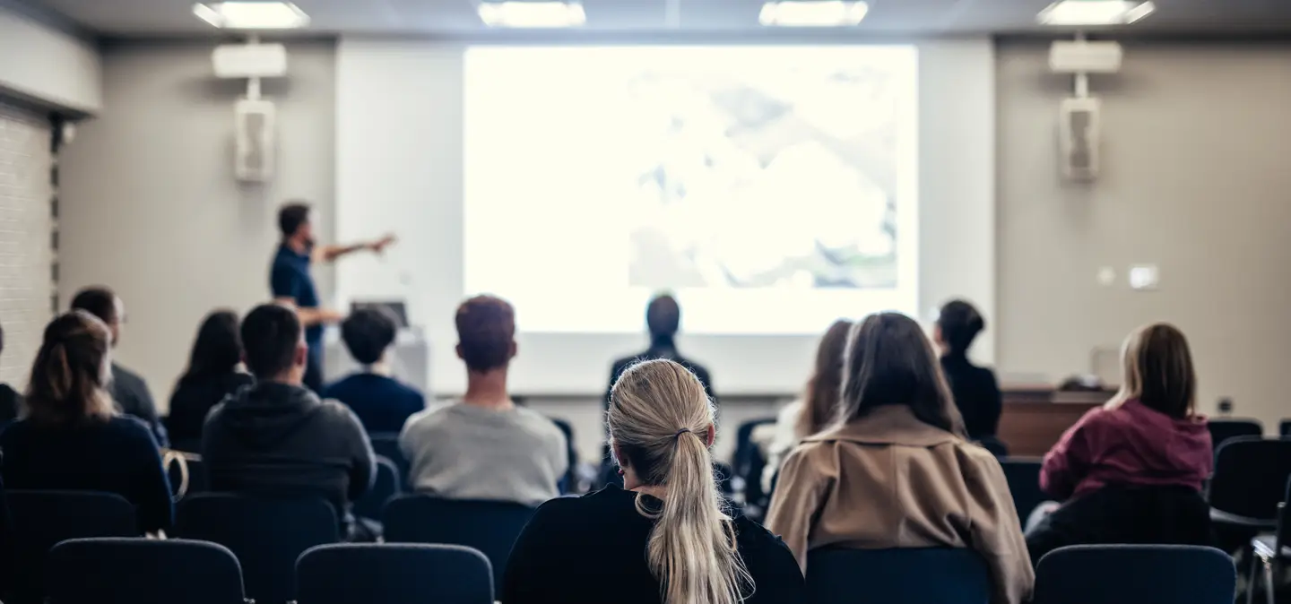 speaker-giving-talk-conference-hall-business-event-rear-view-unrecognizable-people